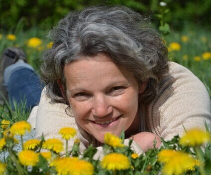 Heilpraktikerin Beate Heydkamp lächelnd in einer Blumenwiese – Expertin für Pflanzenheilkunde